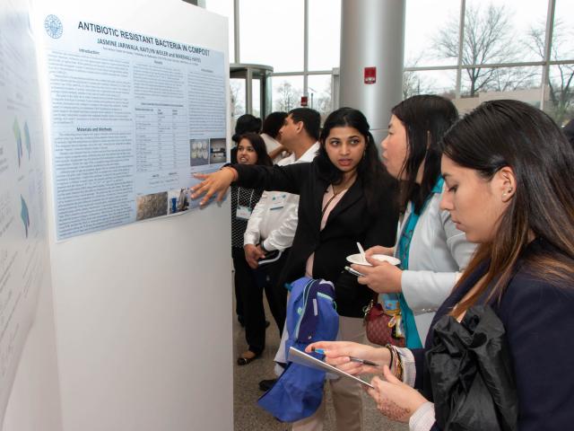 Kean University student giving poster board presentation at Research Days