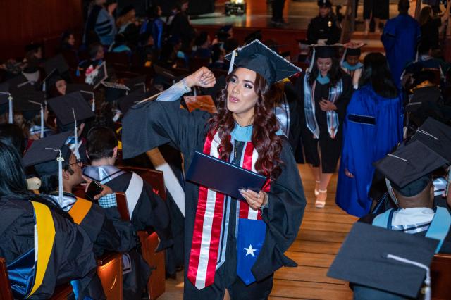 Graduate pumps her fist after she earned her graduate degree