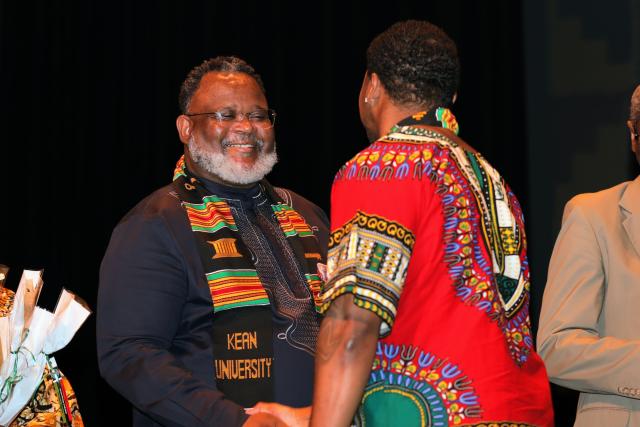 President Repollet greets graduates crossing the stage. 