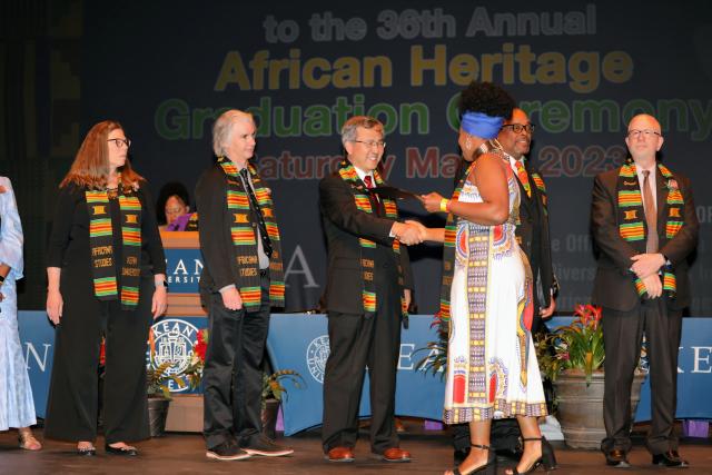 Graduates cross the stage to greet Kean Senior Management