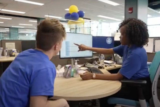 A Kean advisor points to a video screen as a student looks on.