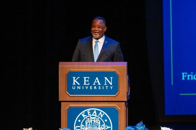 President Repollet speaking on stage behind a podium