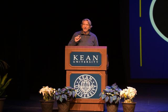 John Prendergast speaking on stage behind a podium