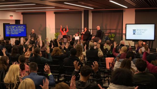 Lauren Ridloff gives her lecture, the audience use their hands to show applause