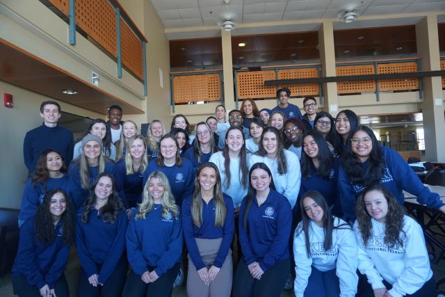 Group photo of the second year OT students in the graduate student lounge on East Campus 