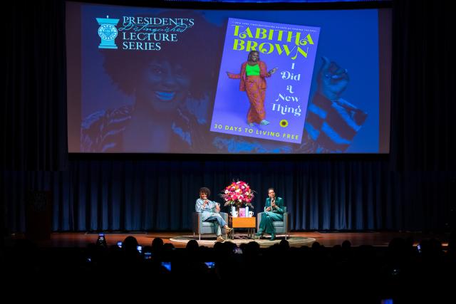 Tabitha Brown and Darlene Repollet on stage. Above them is a picture of Tabitha's book.