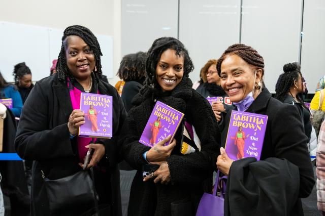 Fans of Tabitha Brown smile and hold up their new books