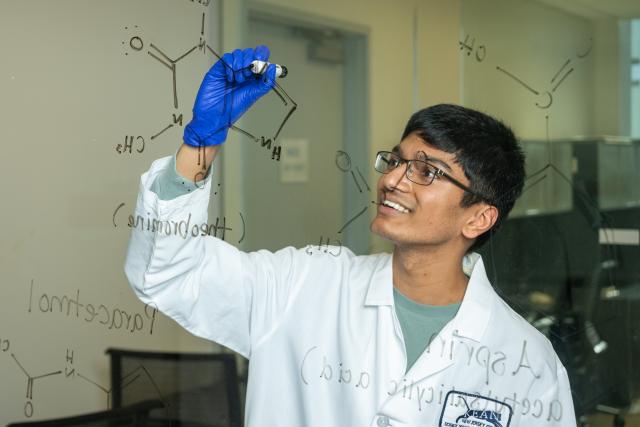 Kean student draws on a laboratory wall