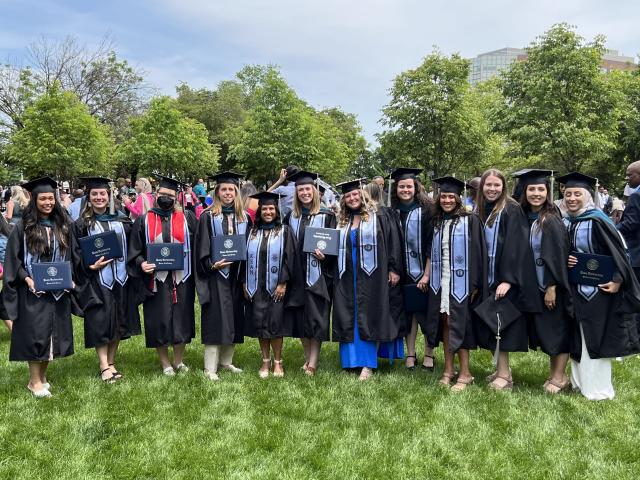 Outdoor group photo of Kean's 2023 graduates in cap and gown