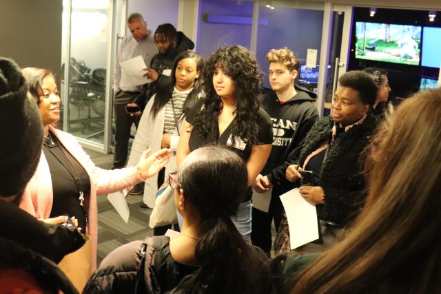 Group of students of different cultural backgrounds listening to a speaker during a tour