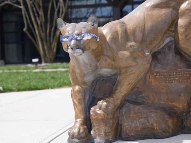 Copper Statue of Kean Cougar wearing eclipse glasses