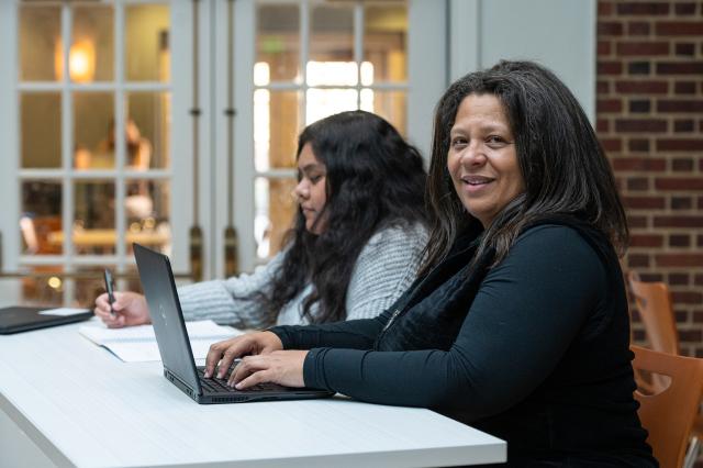 Adult student studies on her patio with teen daughter