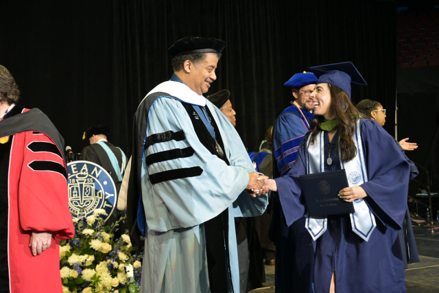 Kean University Neil deGrasse Tyson shakes the hand of a graduating student.