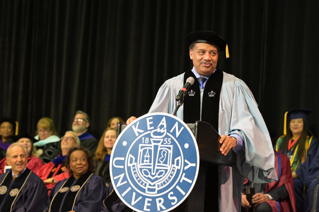 Astrophysicist Neil deGrasse Tyson speaks from a podium at Kean University's Undergraduate Commencement.