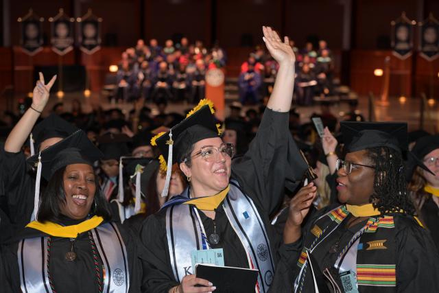 Happy graduates wave in procession