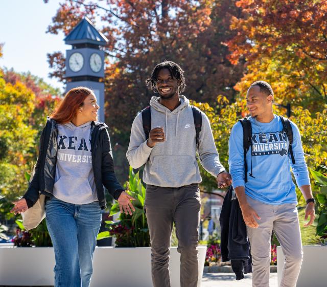 Kean students walk by the clock tower on a Fall day 