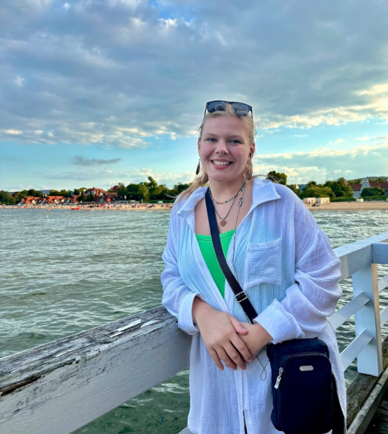 Photo of Julia Mitchell on a dock in front of water and coastline