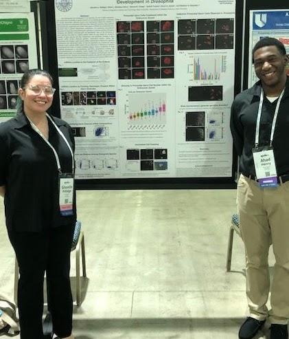 Gisselle and Ahad in front of their poster