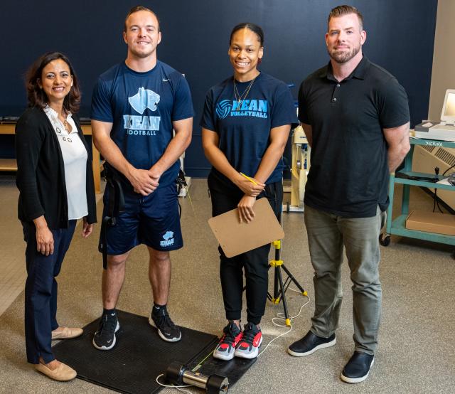 Four people posing two of them wearing Kean athletic wear