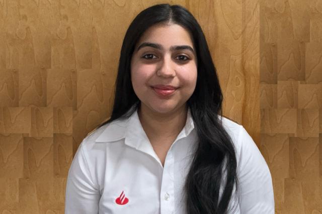 girl with long straight black hair wearing a white shirt with a red Santander Bank logo on the right