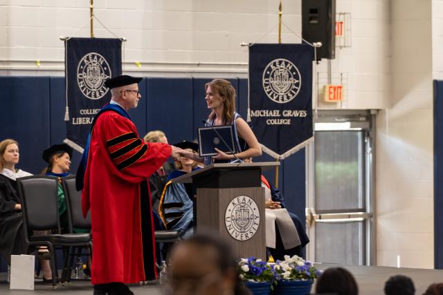 Provost David Birdsell shakes hand of an Honors graduate