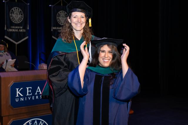 Kean doctoral candidate adjusts her cap at the Doctoral Hooding Ceremony