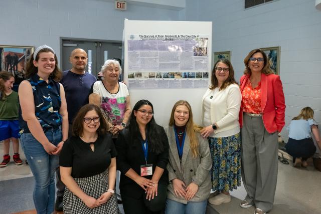 Group of individuals gathered around a Research Days poster