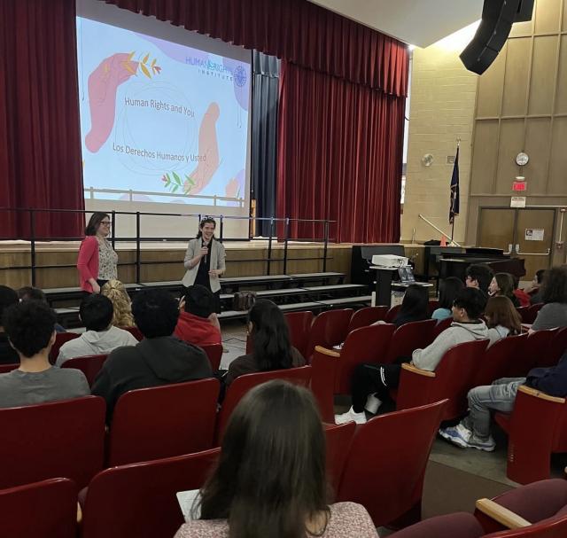 Adara & Sarah presenting "Human Rights & You" to an audience in theater