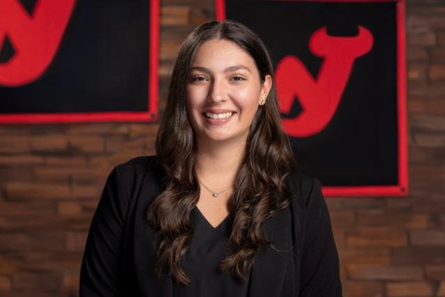Christina Chiarella poses in front of the NJ Devils logo