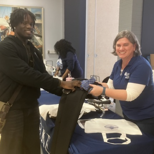 Ms. Grove assisting a student at the checkout with his selection.