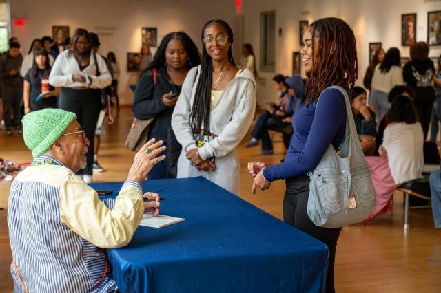 Poet Juan Herrera signing his book for a student
