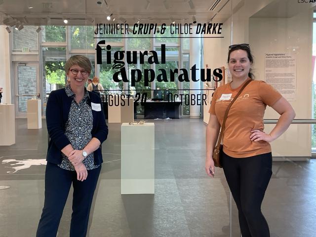 two women standing among an art exhibition