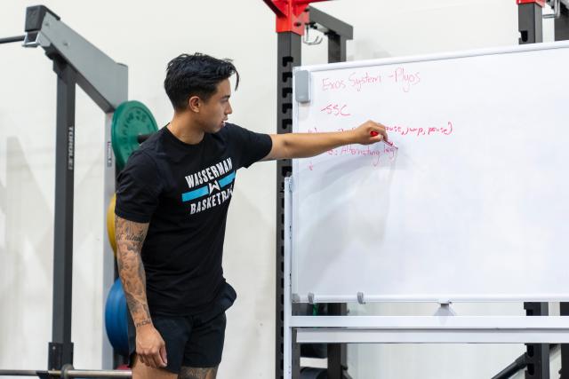 physical therapist writing on white board
