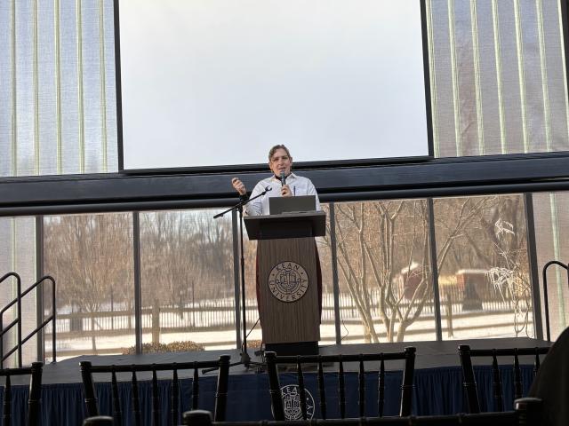 A conference speaker presents at Dialogue Between the West and East