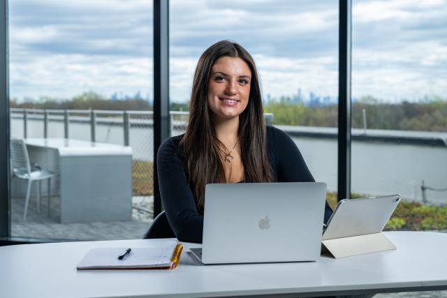 A Kean Global student studies in an office building with a stunning view
