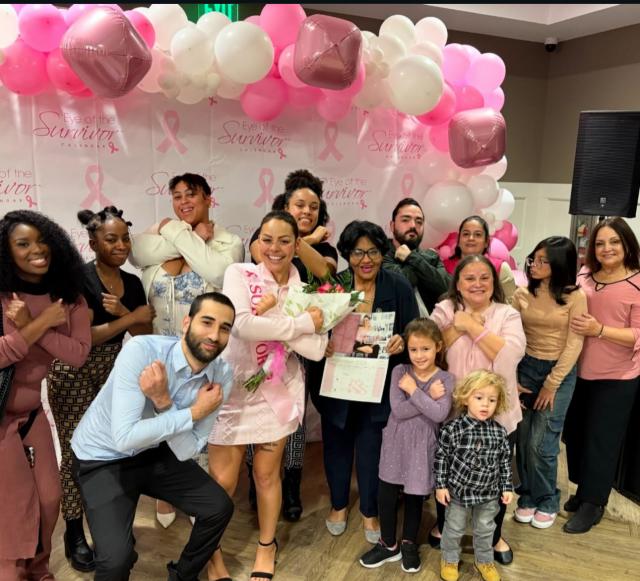 Large group of people surrounded by pink and white balloons