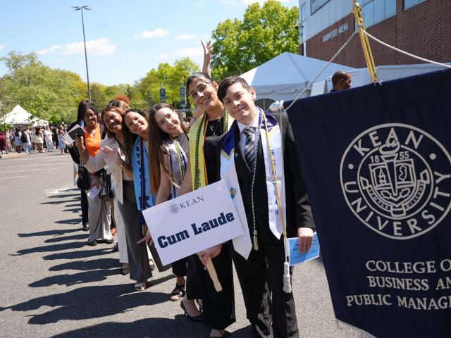Students lined up outside with a white sign and blue banner