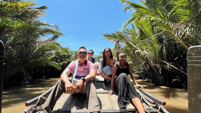 Two men and two women on a boat on a beach