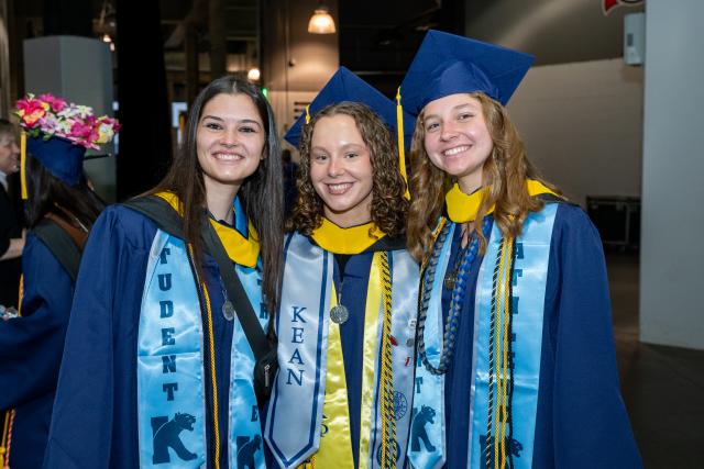 Three Kean students pictured at the University's 2026 commencement ceremony.