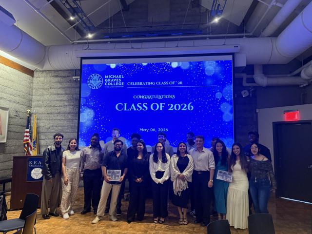 Students holding awards in front of a screen