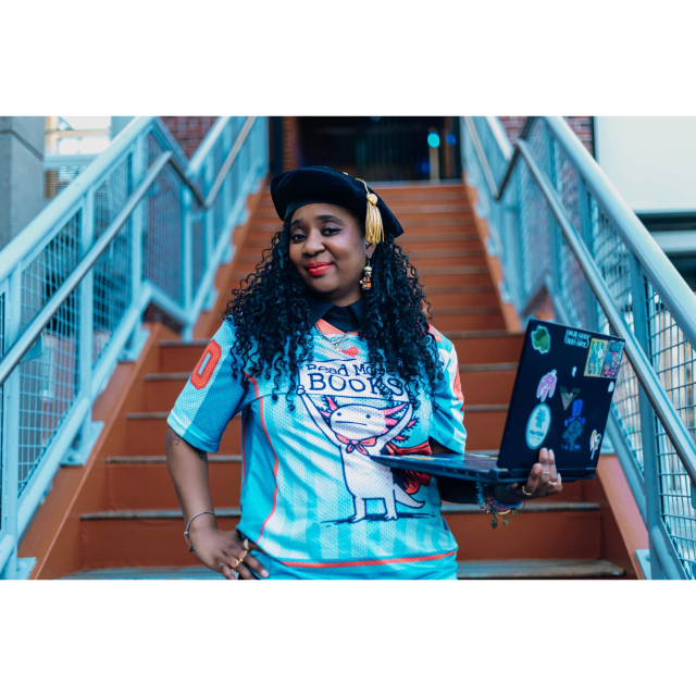 Woman standing on stairs with a laptop