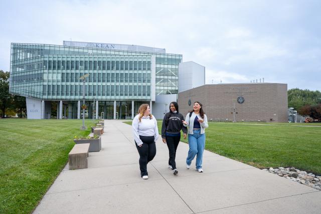 Three students walking across campus