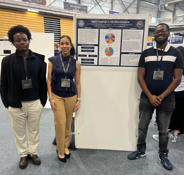 Three students around their Research Days poster