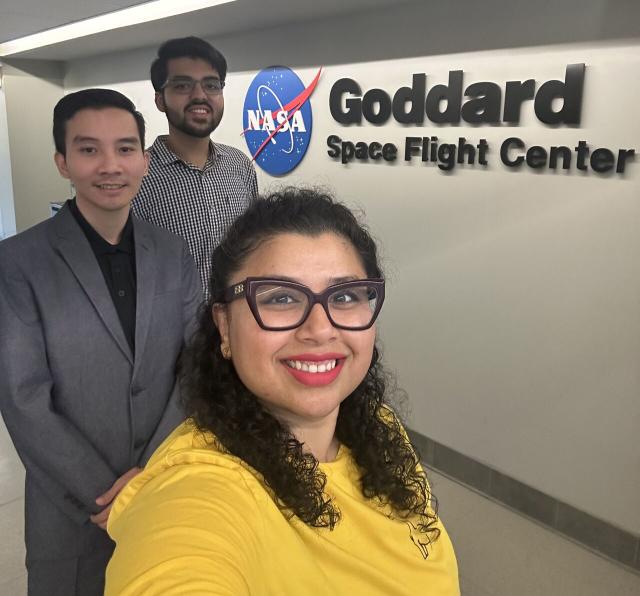 Woman taking a photo of herself and two males at NASA's Goddard Space Flight Center