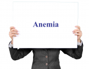 Person holding a sign that says "Anemia"