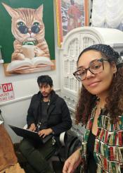 Man with dark sitting and posing for photo with woman with dark and glasses