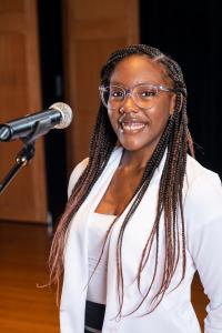 Makiah Robinson smiles as she stands at a microphone