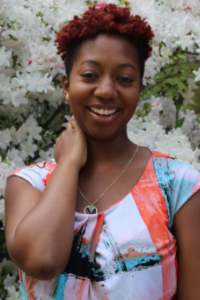 Schane Flowers stands in front of flowers